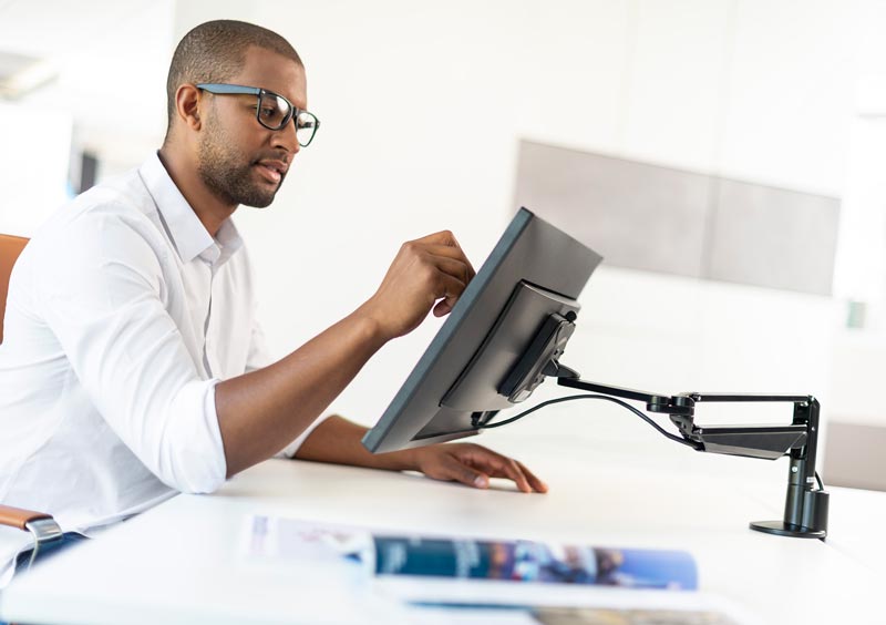 Man using Novus Clu monitor arm